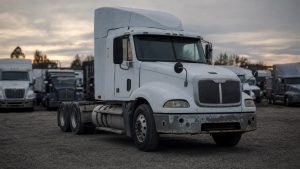 lease purchase трака — старый подержанный тягач с ржавым бампером на площадке дилера